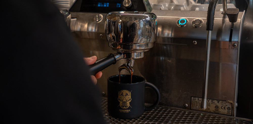 Espresso shot pouring from a portafilter into a glass