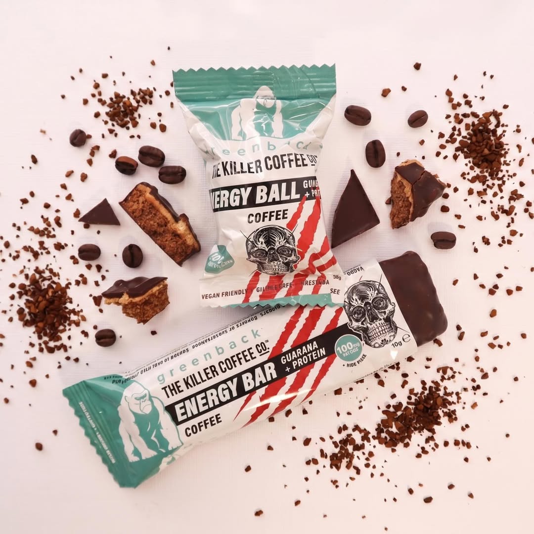 Energy bars and balls with coffee-themed packaging on a white background with coffee beans.